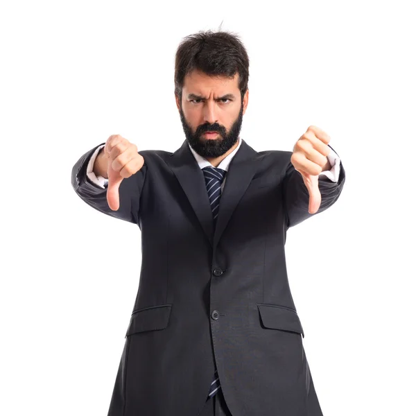 Businessman doing a bad signal over white background — Stock Photo, Image