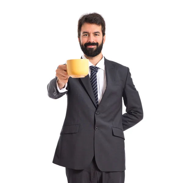 Podnikatel, držící šálek kávy na bílém pozadí — Stock fotografie