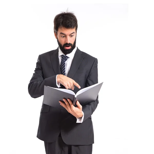 Verrast zakenman lezen van een boek op witte achtergrond — Stockfoto