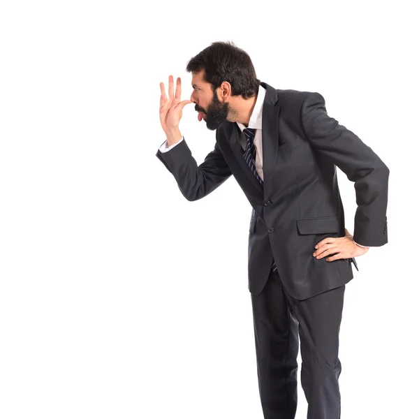 Businessman making a joke over white background — Stock Photo, Image