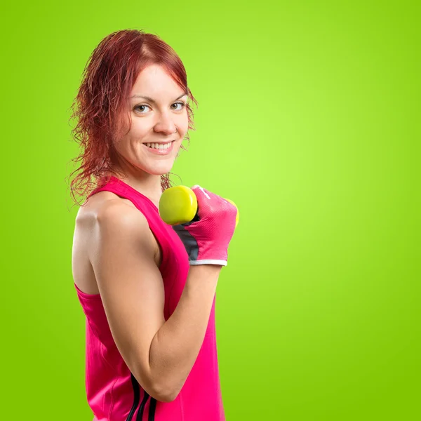 緑の背景上で重量挙げを行う女性 — ストック写真