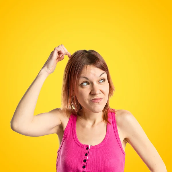 Menina bonito pensando uma ideia sobre fundo amarelo isolado — Fotografia de Stock