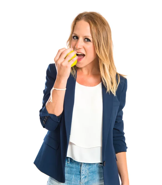 Chica rubia comiendo una manzana sobre fondo blanco — Foto de Stock