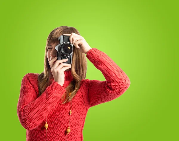 Woman photographing over green background — Stock Photo, Image