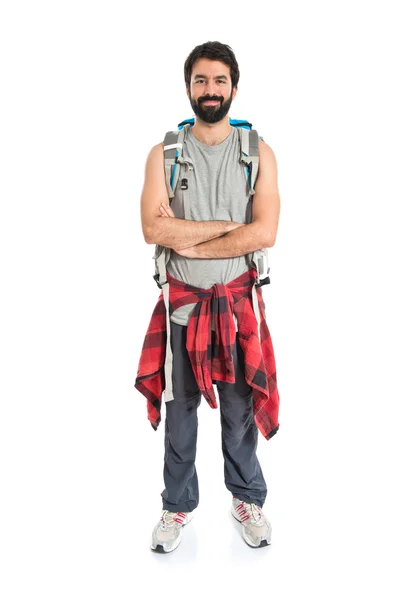 Backpacker met zijn armen overgestoken op witte achtergrond Stockfoto