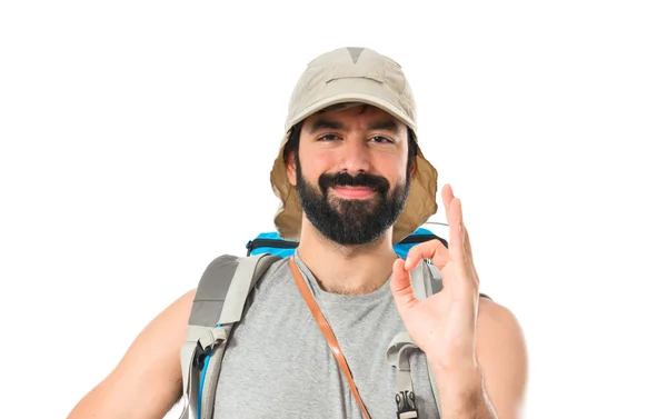 Backpacker making Ok sign over white background Лицензионные Стоковые Изображения