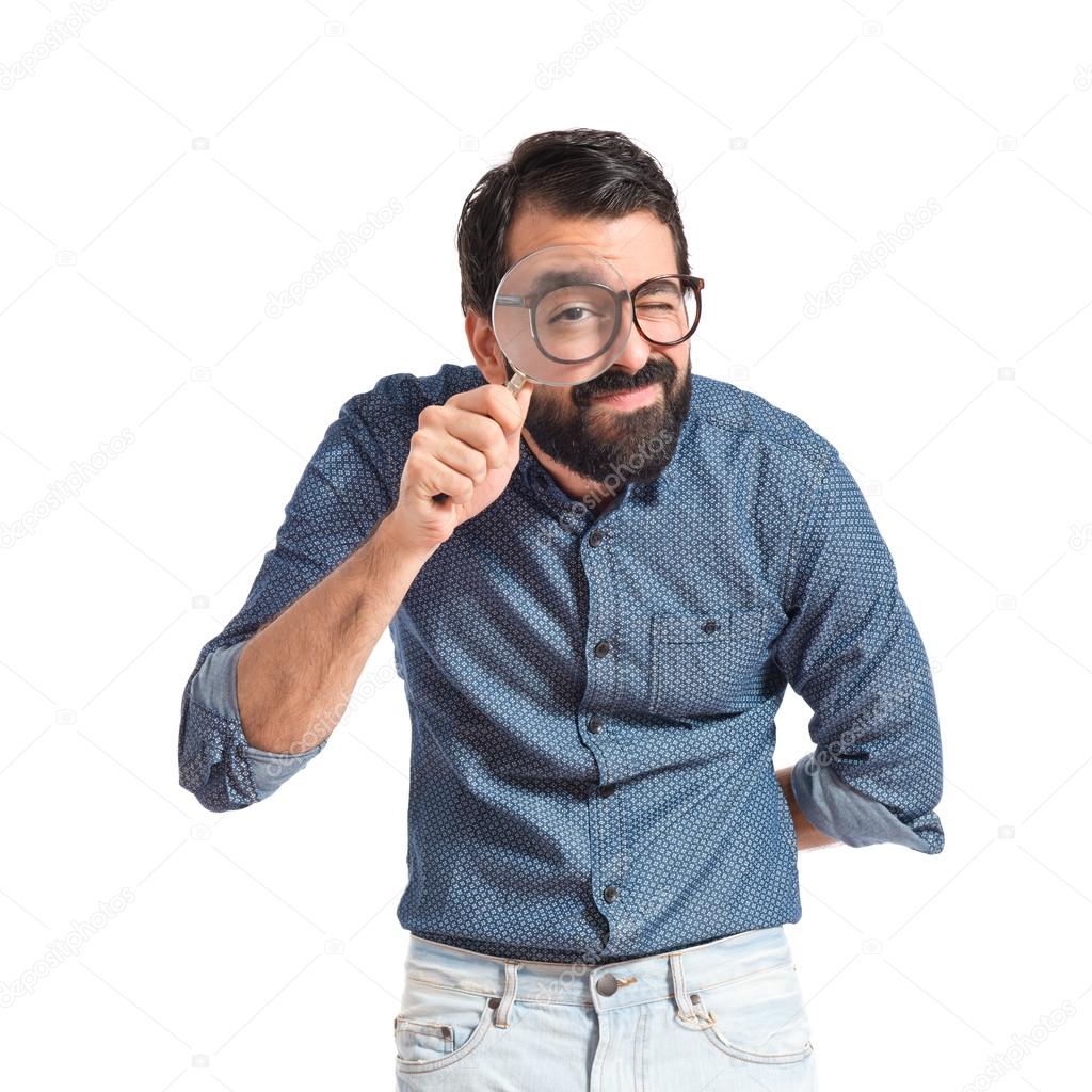 Young hipster man with magnifying glass