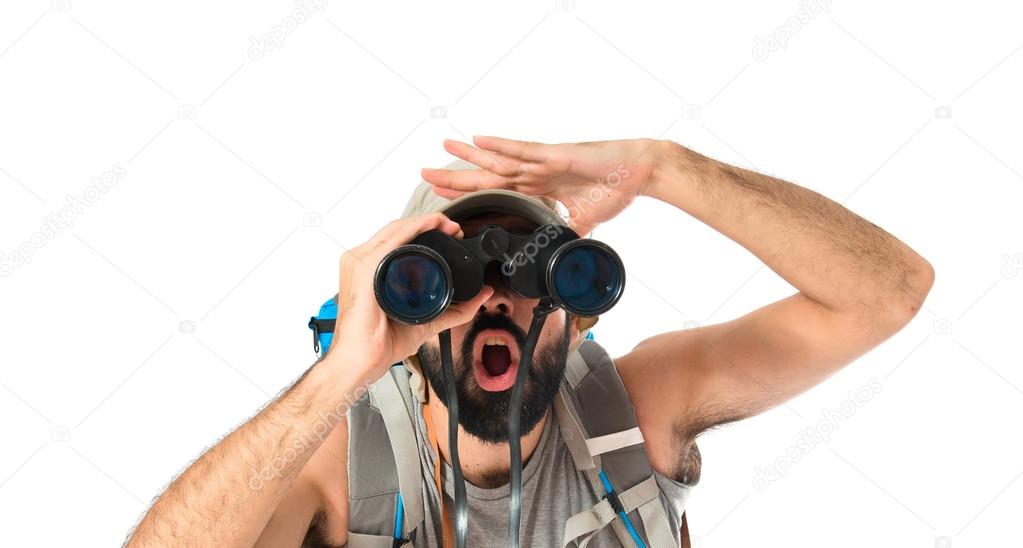 Backpacker with binoculars over isolated white background