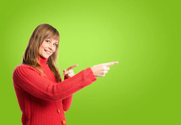 Woman pointing to the lateral over green background — Stock Photo, Image