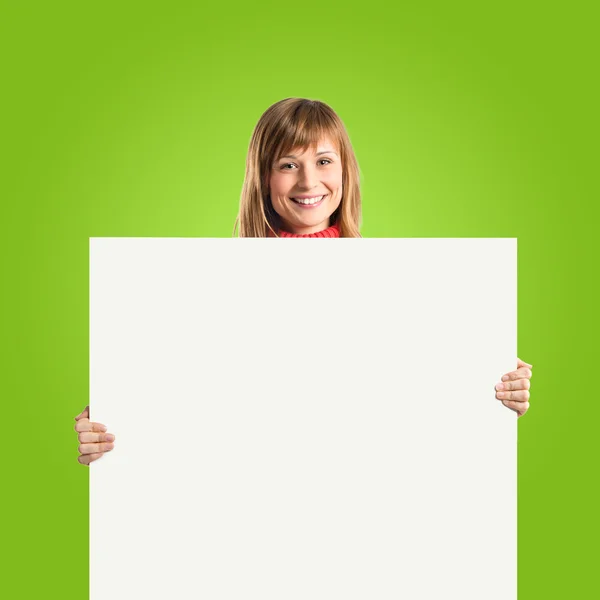 Женщина с пустым плакатом на зеленом фоне — стоковое фото