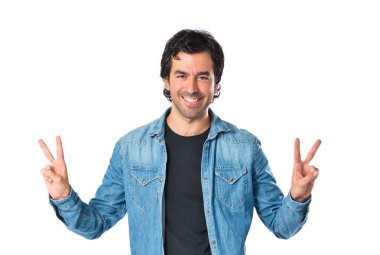Beyaz arka plan üzerinde zafer hareketi yapan erkek
