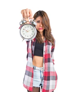 Beyaz arka plan üzerinde bir saat tutan kız