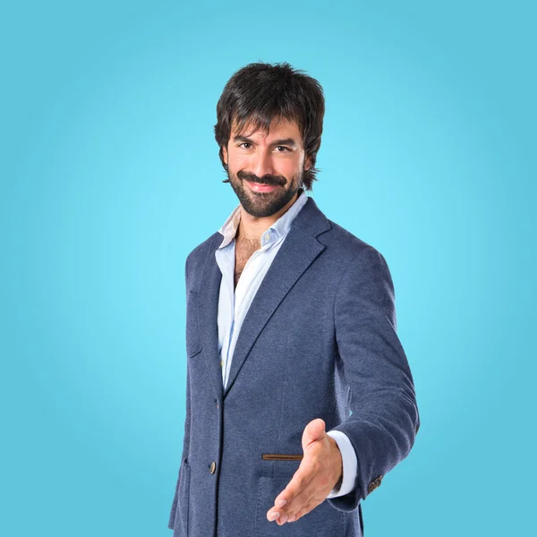 Businessman making a deal over blue background — Stock Photo, Image