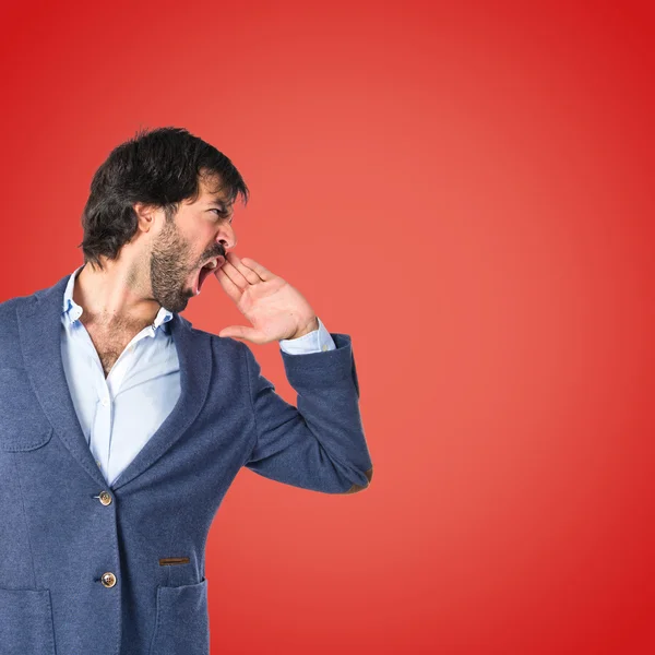 Empresário gritando sobre fundo vermelho — Fotografia de Stock