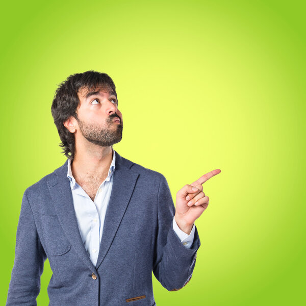 Businessman thinking over green background