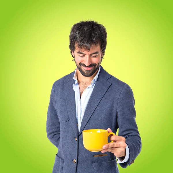 Man met een kopje koffie op groene achtergrond — Stockfoto