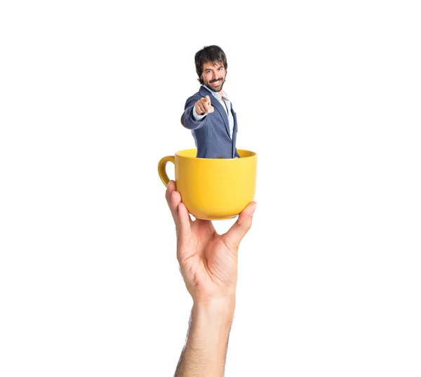 Бизнесмен указывает на переднюю чашку кофе — стоковое фото