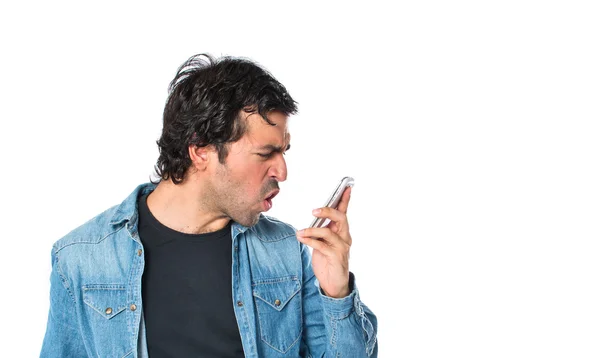 Homem gritando por celular sobre fundo branco — Fotografia de Stock