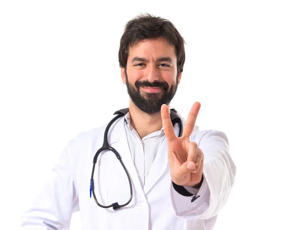 Läkare gör seger gest över vit bakgrund — Stockfoto