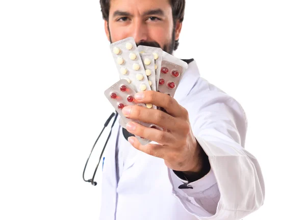 Läkare som innehar piller över vit bakgrund — Stockfoto