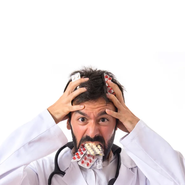 Médecin fou avec des pilules sur fond blanc — Photo