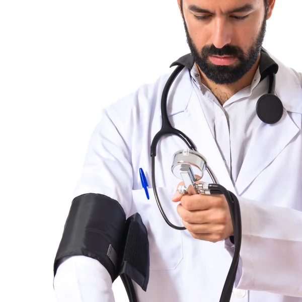 Doctor with blood pressure monitor over white background — Stock Photo, Image