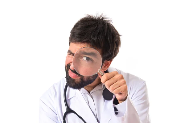 Doctor with magnifying glass over white background — Stock Photo, Image