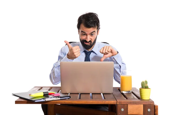 Businessman in his office making good-bad sign — Stock Photo, Image