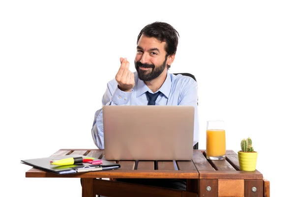 Businessman in his office doing money gesture — Stock Photo, Image