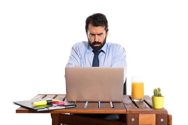 Trauriger Geschäftsmann arbeitet mit seinem Laptop — Stockfoto