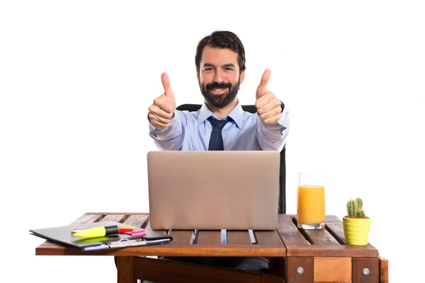 Businessman in his office with thumb up — Stock Photo, Image