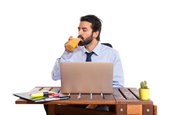 Επιχειρηματίας στο γραφείο του πίνοντας χυμό πορτοκαλιού — Φωτογραφία Αρχείου