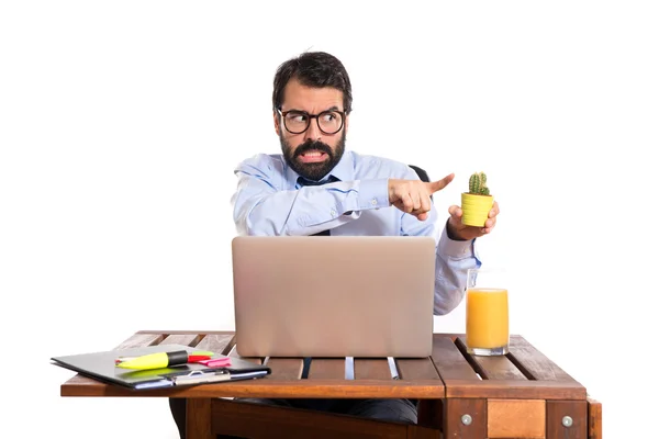 Businessman in his office holding cactus — Stock Photo, Image