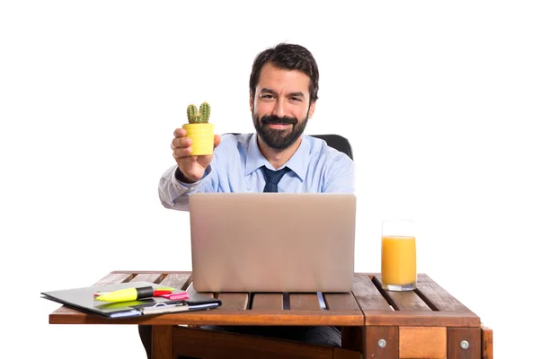 Affärsman i hans kontor hålla cactus — Stockfoto