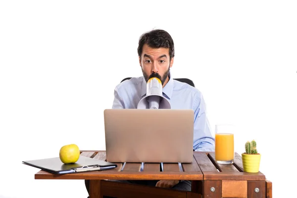 Businessman in his office shouting by megaphone — Stock Photo, Image