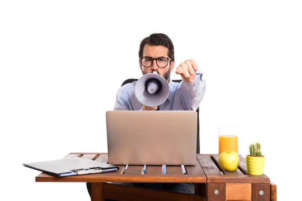 Businessman in his office shouting by megaphone — Stock Photo, Image