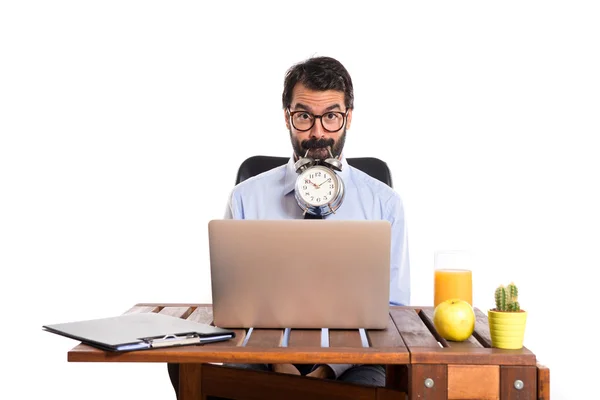Podnikatel v jeho kanceláři drží hodiny — Stock fotografie