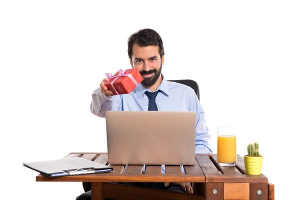 Businessman in his office giving a gift — Stock Photo, Image