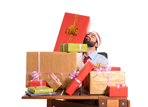 Χριστούγεννα άνθρωπος στο γραφείο του με πολλά δώρα — Φωτογραφία Αρχείου