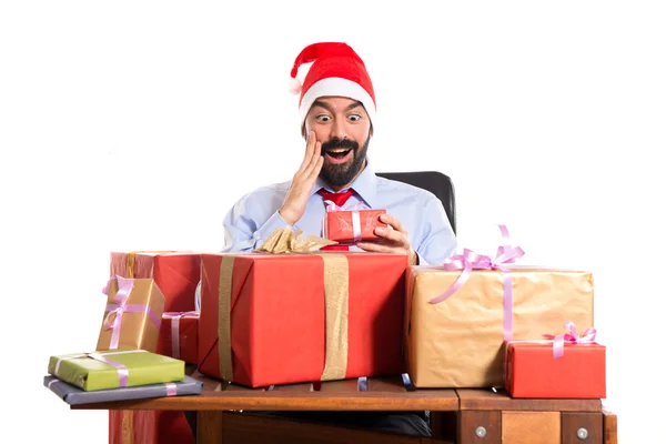 Christmas man in his office with several gifts — Stock Photo, Image