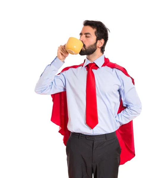 Biznesmen ubrany jak superbohater picia kawy — Zdjęcie stockowe