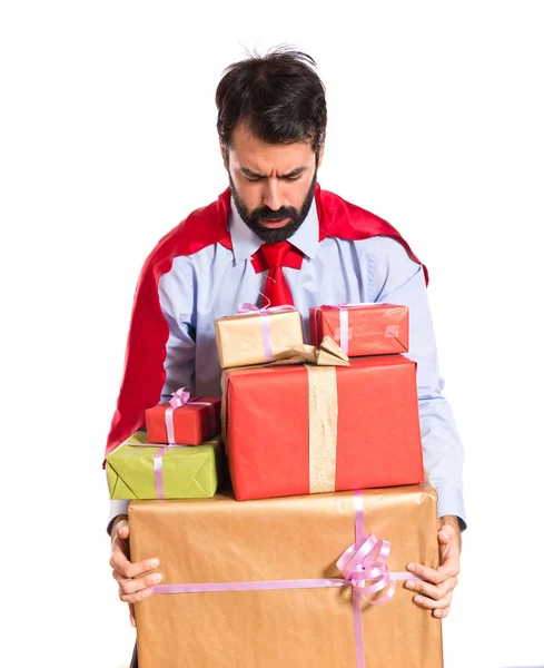 Businessman dressed like superhero holding gifts — Stock Photo, Image