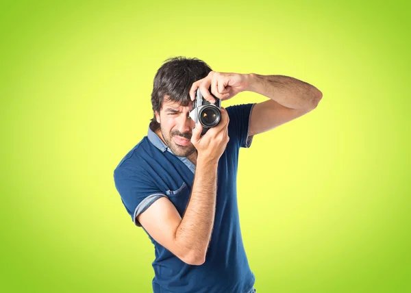 Man photographing over green background — Stock Photo, Image