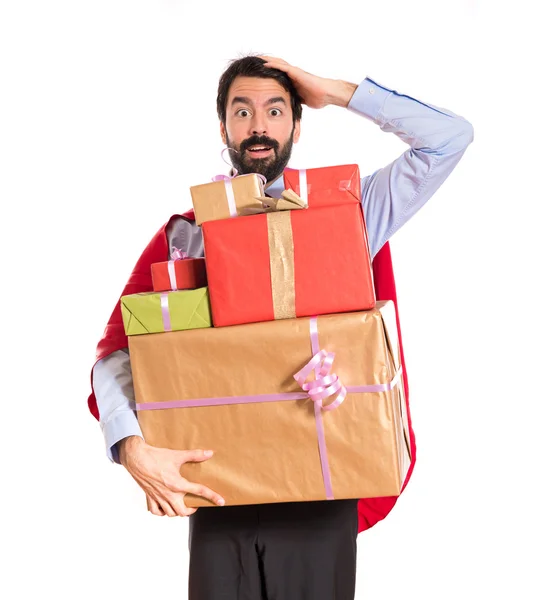 Surprise businessman dressed like superhero holding gifts — Stock Photo, Image