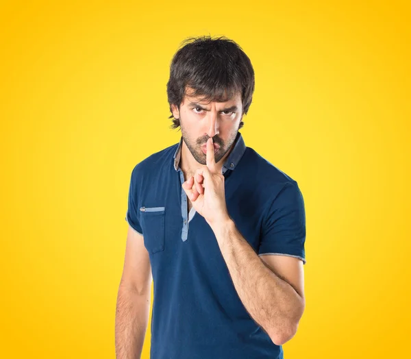 Muž při mlčení gesto na žlutém pozadí — Stock fotografie
