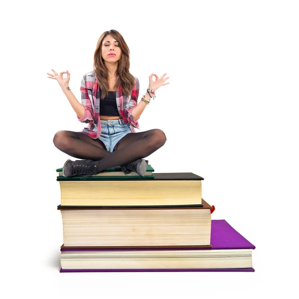 Pretty girl in zen position sitting on book — Stock Photo, Image