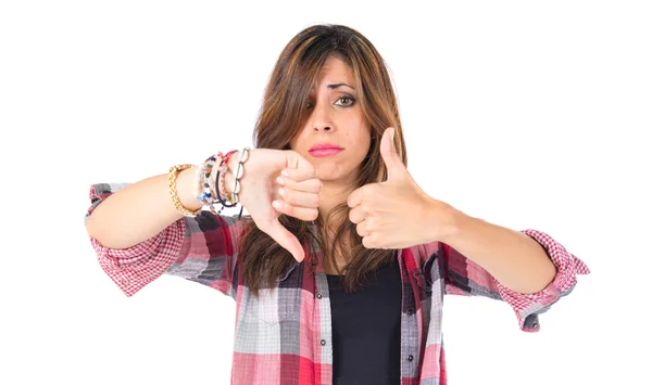 Chica haciendo una buena-mala señal sobre fondo blanco — Foto de Stock