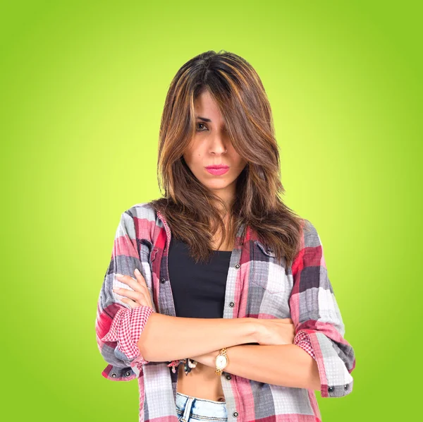 Meisje met haar armen overgestoken op groene achtergrond — Stockfoto