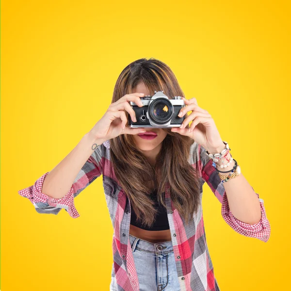 Chica bonita fotografiando sobre fondo amarillo — Foto de Stock