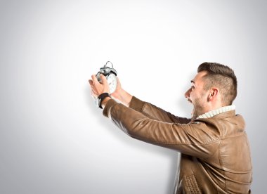 Bir antika saat gri arka plan üzerinde tutan genç işadamı 